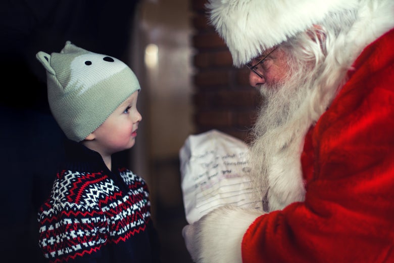 A small child looks at Santa Claus